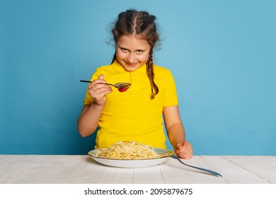 Crazy Look. Cute Little Girl, Emotive Kid Eating Delicious Italian Pasta Isolated On Blue Studio Background. Holidays, Traditions, Food, Childhood, Cafe, Love. Healthy And Unhealthy Eating.