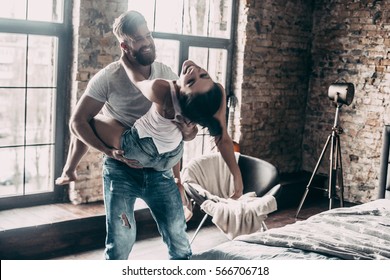 Crazy In Love. Young Passionate Couple Having Fun Together And Looking Happy While Handsome Young Man Carrying His Girlfriend On Shoulders