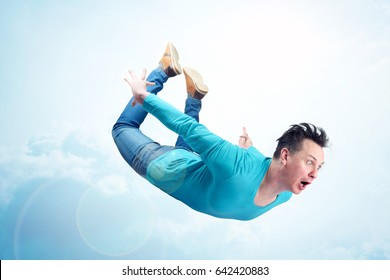 Crazy man in blue shirt and jeans is flying in the sky. Jumper concept