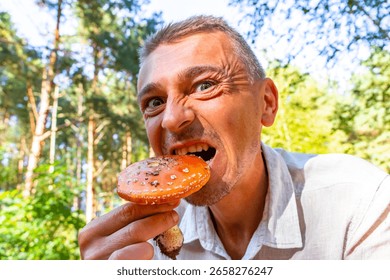 Crazy man eats a poisonous toadstool in the forest in Leninskiy Rayon Brest Brest District Brest Region Belarus.