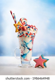 Crazy Milk Shake With Ice Cream,whipped Cream, Marshmallow,cookies And Colored Candy In Glass. Sweet Dessert For Fourth Of July. Idea Milkshake For Patriotic Day.