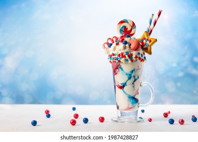 Crazy Milk Shake With Ice Cream,whipped Cream, Marshmallow,cookies And Colored Candy In Glass. Sweet Dessert For Fourth Of July. Idea Milkshake For Patriotic Day.