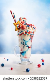 Crazy Milk Shake With Ice Cream,whipped Cream, Marshmallow,cookies And Colored Candy In Glass. Sweet Dessert For Fourth Of July. Idea Milkshake For Patriotic Day.