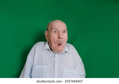 A Crazy Old Man Makes Faces And Grimaces Against An Isolated Green Background. Chromakey