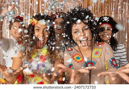 Crazy people throwing confetti in Brazil Carnaval. Friends having fun at Brazilian Carnival party.