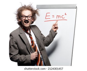 Crazy Professor, Scientist, Lecturer With Mad Hairstyle Wearing Horn Rimmed Glasses And Fake Mustache Standing In Front Of A Whiteboard And Pointing At Formula E=mc With Happy Goofy Face