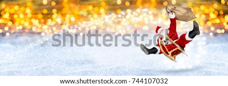 crazy santa claus flying on his sleigh with bag of presents in front of snowy  bright golden lights bokeh wide panorama background