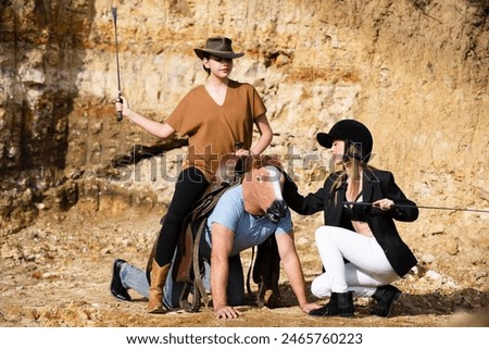 Crazy strange people with horse mask. Freaky young horsewoman women dominant man with horse mask. Dominant girls. Absurd and funny friends. Crazy dominant game. Dominatrix.