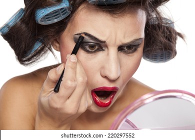 Crazy Woman With Curlers And Bad Makeup Applied Pencil On Eyebrows