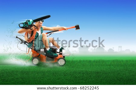Crazy workman covered with instruments driving lawn mower over green grass