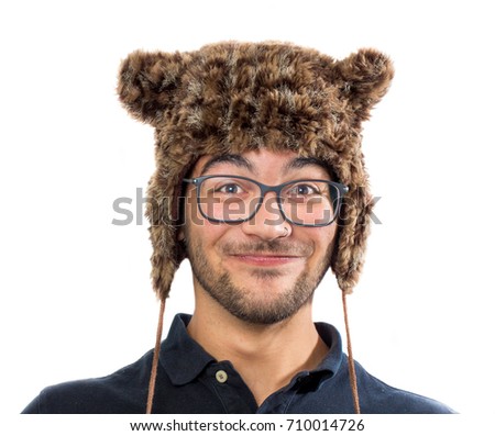 Crazy young man with funny face wearing a bear hat isolated on white background