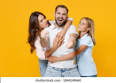 Crazy Young Parents Mom Dad Child Kid Daughter Teen Girl In Basic T-shirts Holding Hands Like Riding Car Hugging Isolated On Yellow Background Studio Portrait. Family Day Parenthood Childhood Concept