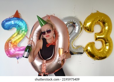 Crazy Young Woman Making Funny Face. Lonely Girl Celebrating New Year 2023 At Home. Silvester Party. December 31. January 1. Big Number Balloons. Lady Posing In Hole Of Zero Shaped Balloon.