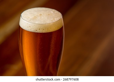 Cream Ale In Pilsner Style Glass On Wood Background.