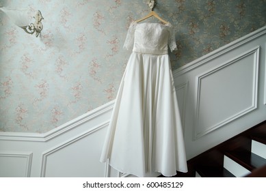 Cream bride hang on the lamp against the wall next to the stairs in the hotel - Powered by Shutterstock