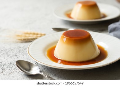 Cream caramel pudding with caramel sauce in plate on white rustic table
