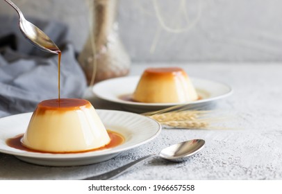 Cream caramel pudding with caramel sauce in plate on white rustic table