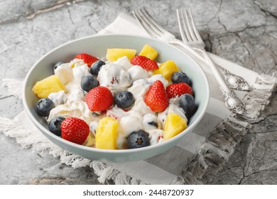 Cream cheese salad with strawberries, blueberries, pineapple close-up in a bowl on a marble table. Horizontal
 - Powered by Shutterstock