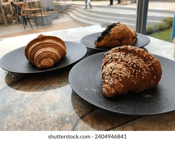 Cream Cheese Truffle, Chocolate, Ham and Cheese Croissants on black plate - Powered by Shutterstock