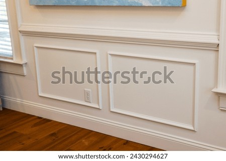 Cream colored architrave decorative wall molding wall trim with skirting and panels in the interior of an old home house.