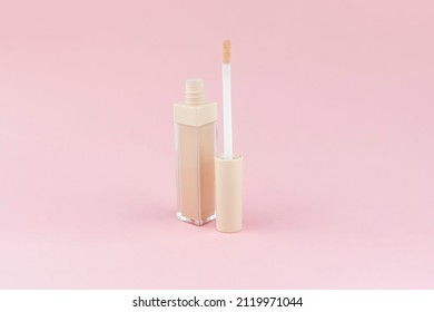 Cream Concealer For Correcting Facial Imperfections With An Applicator On A Pink Background