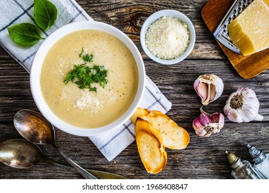 Cream garlic and parmesan soup on wooden table  - Powered by Shutterstock