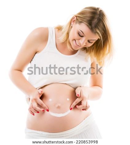 Cream happy smiley face on the belly of pregnant woman
