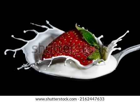 Cream splash, a strawberry falling on it