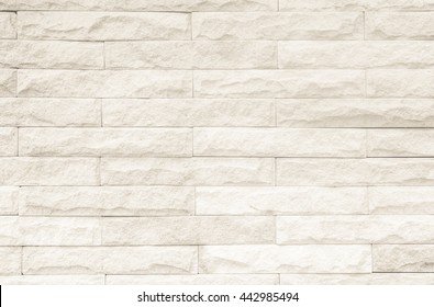 Cream and white brick wall texture background. Brickwork or stonework flooring interior rock old pattern clean concrete grid uneven bricks design stack.