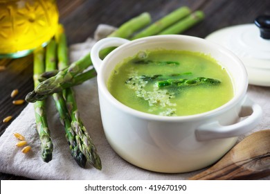 Creamy asparagus soup on wooden background