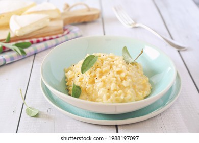 Creamy Brie cheese Risotto on sage broth, light background 