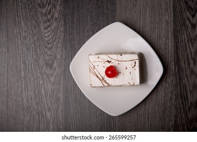 Creamy Cake With Cherry On White Plate, Top View 