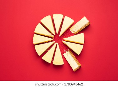 Creamy cheesecake sliced with interior section, isolated on a red background. Top view of delicious cheese pie slices. Sliced cake. Christmas dessert.