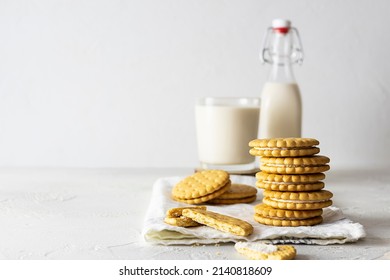 Creamy cookies with filling on a light napkin. A bottle and a glass of milk in the background. White background, text space - Powered by Shutterstock