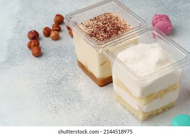 Creamy dessert in a plastic box on gray table