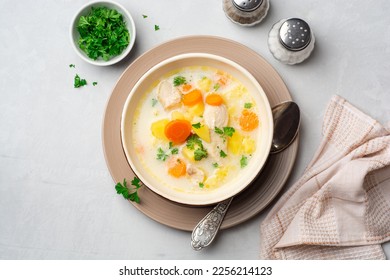 Creamy fish chowder soup in bowl on concrete background. Top view.