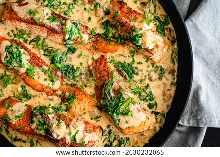 Creamy Garlic Butter Tuscan Salmon in a Skillet: Salmon fillets in a creamy parmesan sauce with spinach and sun-dried tomatoes