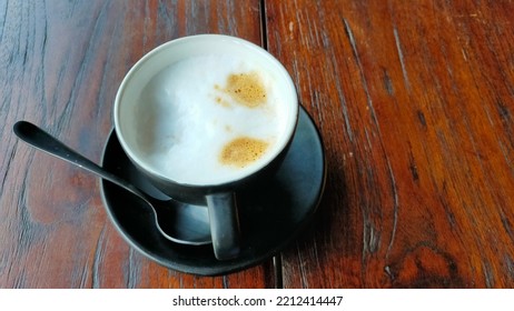 Creamy Latte Coffee In A Cup Of Black Glass