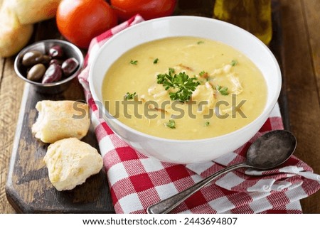 Creamy lemon chicken soup with rice garnished with parsley