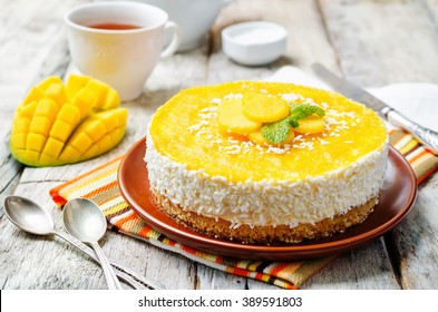 creamy mango mousse cake on a white wood background. toning. selective focus