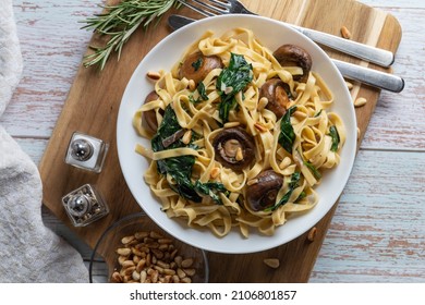 Creamy Mushroom Spinach Pasta. Rustic Pasta With Mushrooms, Creamy Spinach Sauce And Parsley On A Wooden Background, Top Wiev