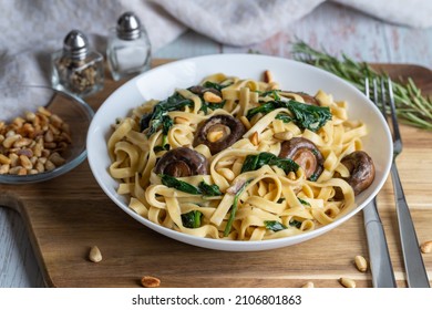 Creamy Mushroom Spinach Pasta. Rustic Pasta With Mushrooms, Creamy Spinach Sauce And Parsley On A Wooden Background