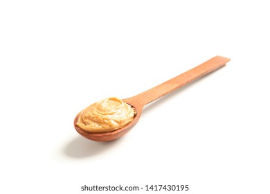 Creamy peanut butter in wooden spoon isolated on white background. A traditional product of American cuisine - Powered by Shutterstock