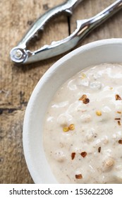 A Creamy Spicy Crab And Sweet Corn Chowder With Claw Cracker In The Background.