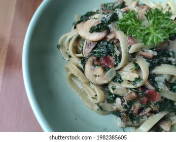 Creamy Spinach Mushroom Pasta On The Wooden Table