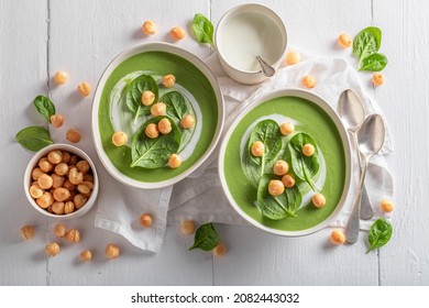 Creamy spinach soup with peas puff, leaves and cream. Vegan soup made of green vegetables.