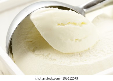 creamy vanilla ice cream in a white cup with a special spoon