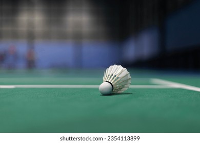A creamy white badminton ball placed on a green background.