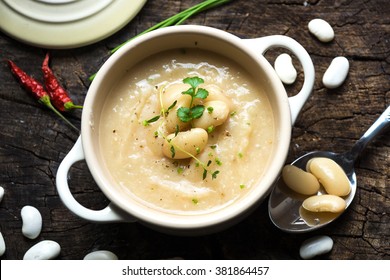 Creamy white bean soup on wooden background