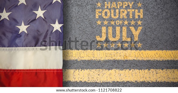 Creased US flag against yellow road marking on\
road surface